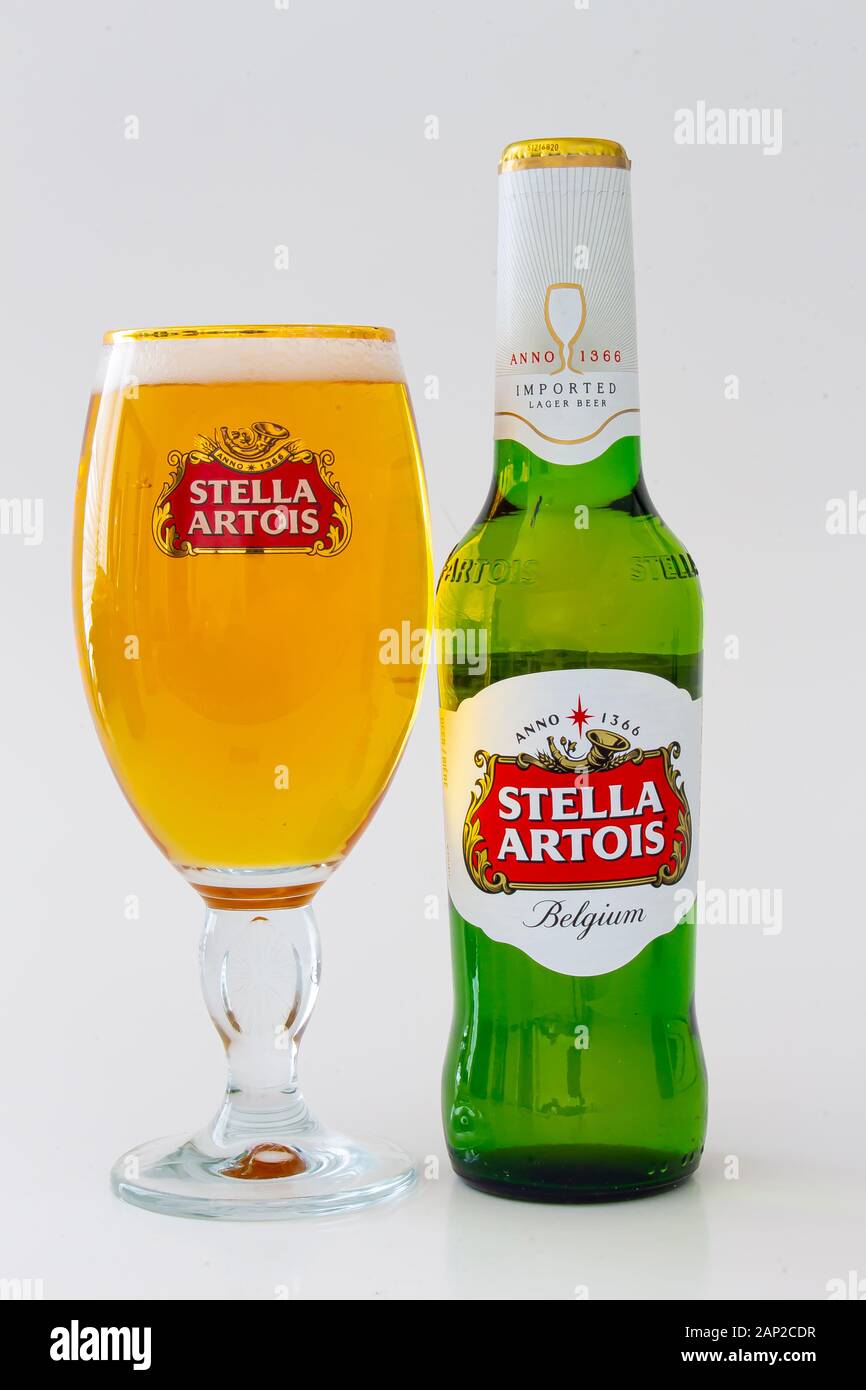 A bottle of a Stella Artois beer with a beer cup on the side Stock Photo