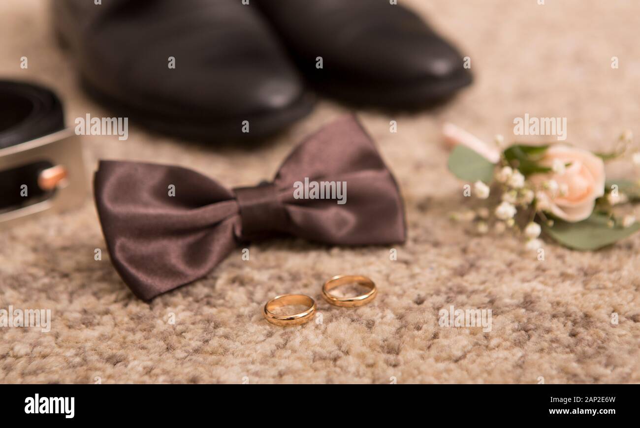 Close up of wedding bow tie, belt and groom shoes on floor Stock Photo