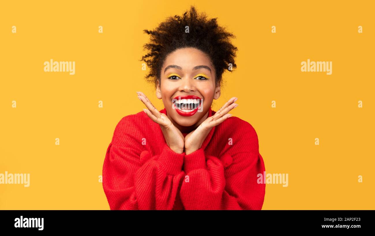Happy afro woman screaming and touching cheeks Stock Photo - Alamy