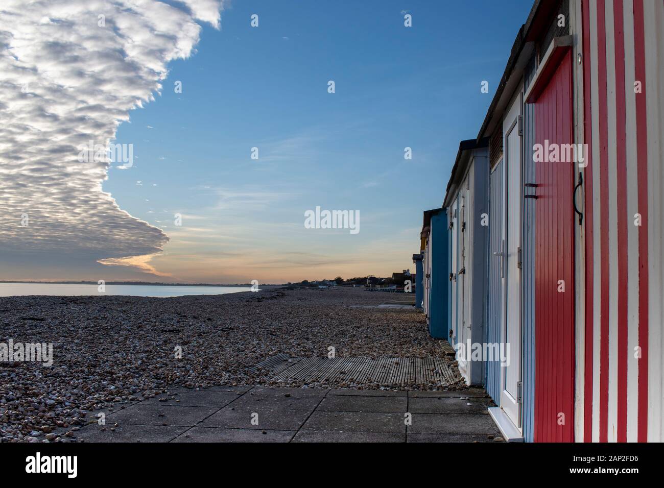 Dramatic cloud formation over the seafront at Bognor Regis with colourful beach huts on the beach and, beautiful colours and reflections of the sea. Stock Photo