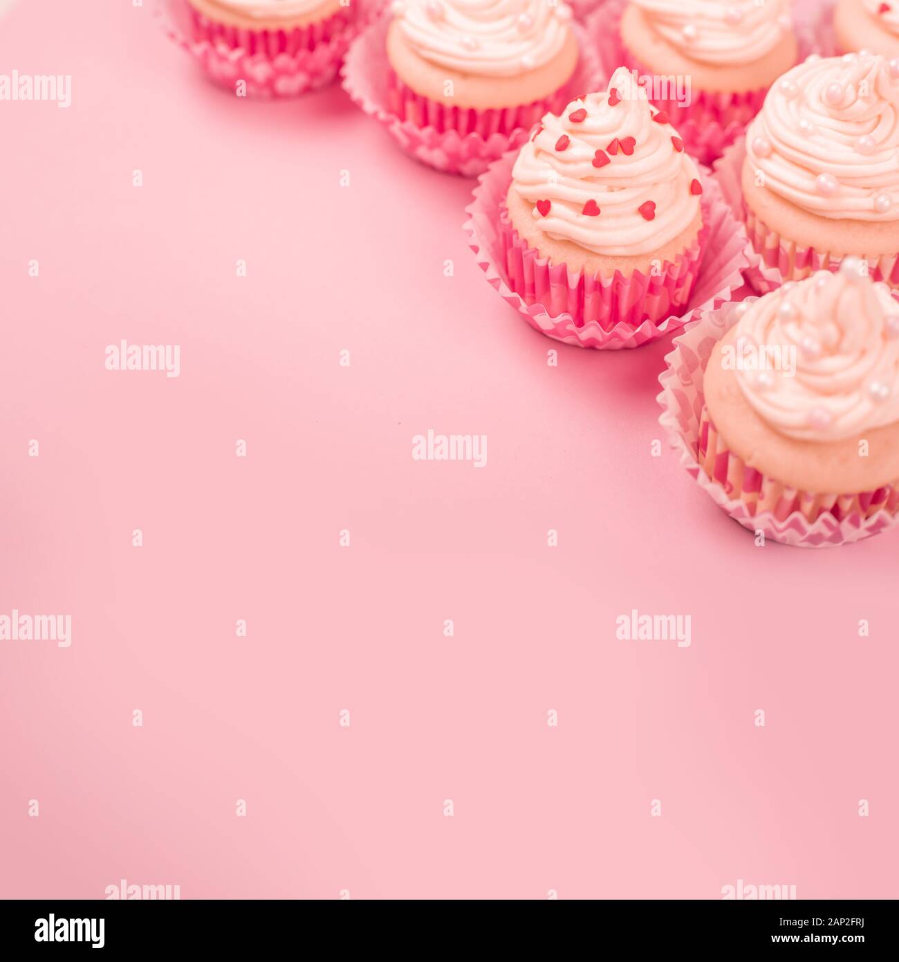 Valentine day love cupcakes decorated with cream and hearts on pink  background with copy space for text Stock Photo - Alamy
