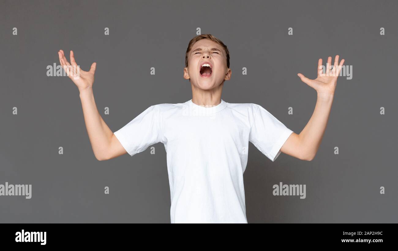 Emotional teenage boy screaming loudly in despair Stock Photo