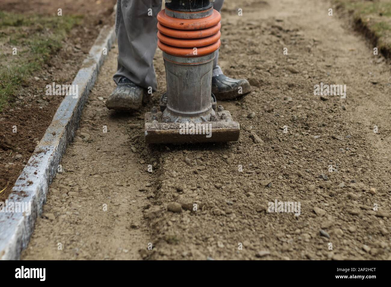 Stamping soil with rammer to build the garden path Stock Photo Alamy