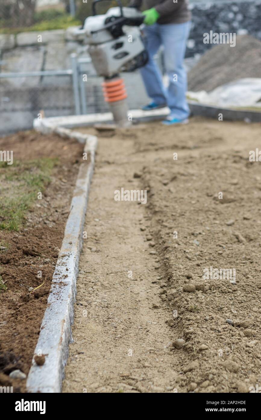 Stamping soil to build the garden path Stock Photo Alamy