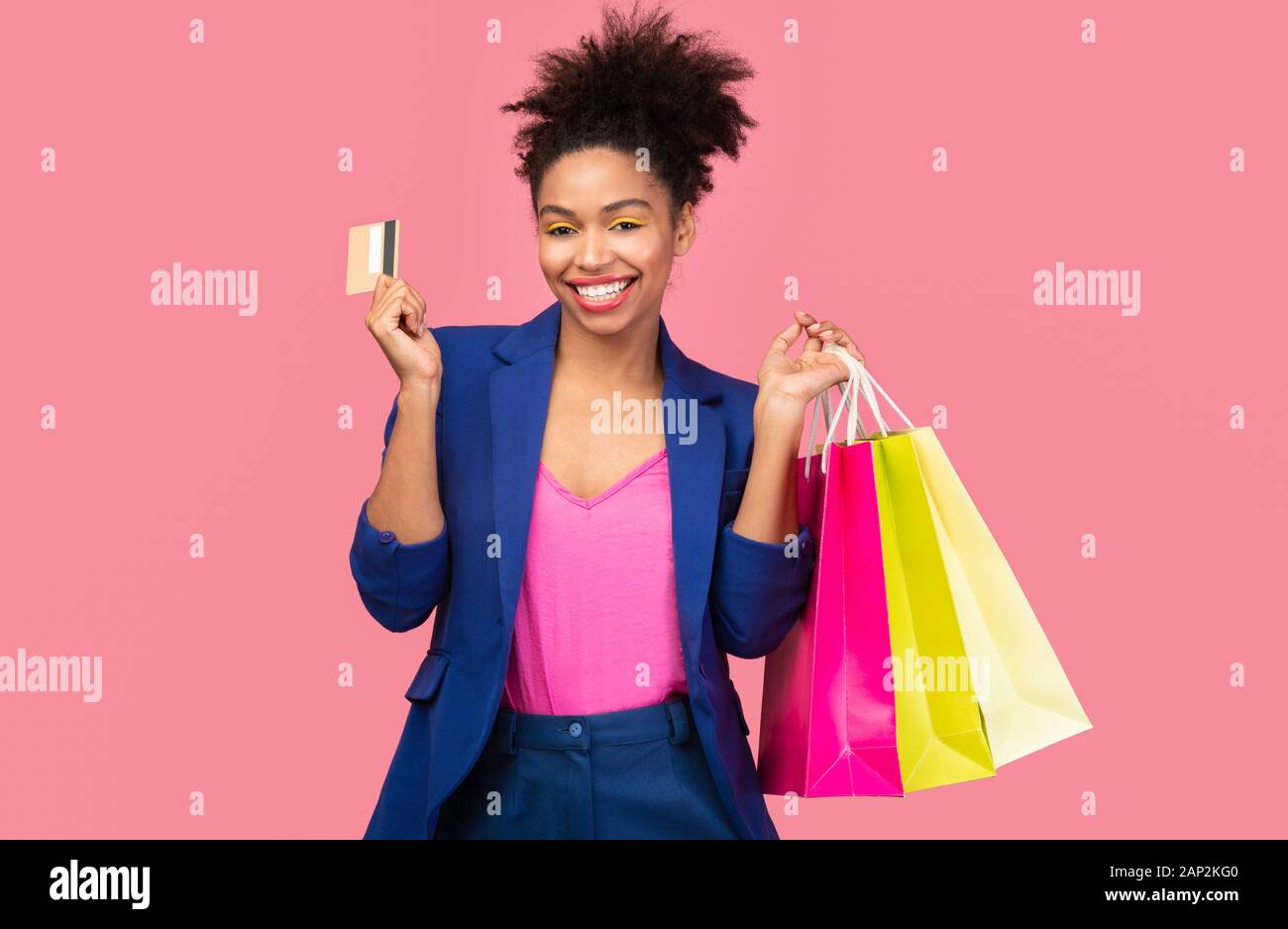 Cheerful black woman with shopping bags and plastic card Stock Photo