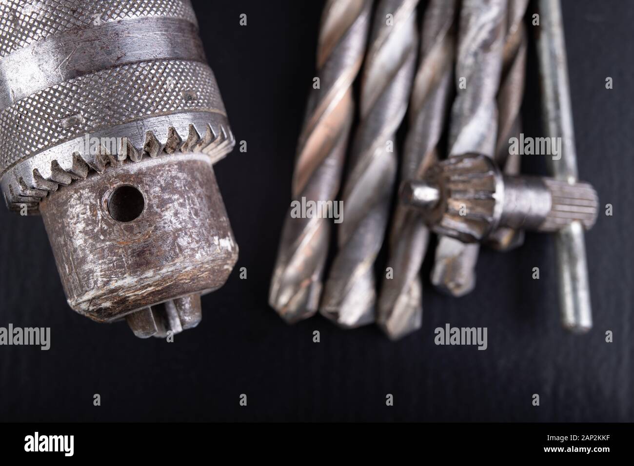 Drill and drills on a workbench. Tools for construction workers. Dark background. Stock Photo