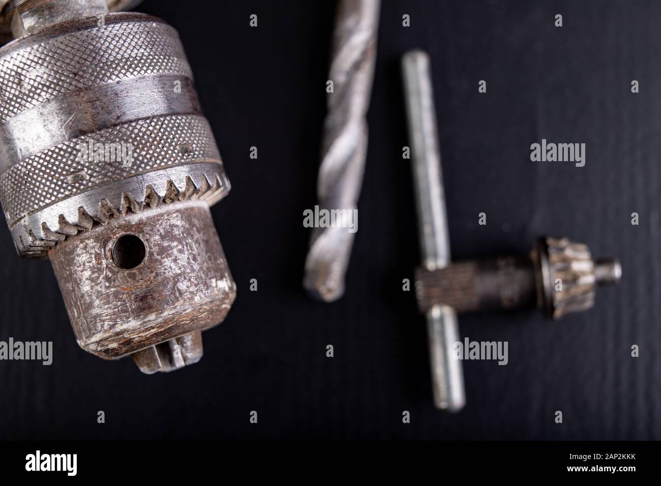 Drill and drills on a workbench. Tools for construction workers. Dark background. Stock Photo