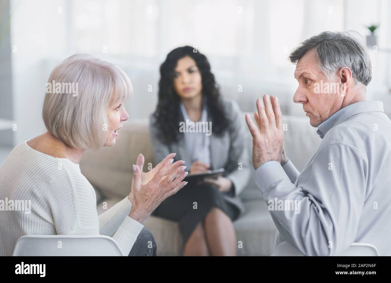 Elderly couple having fight in therapy during session Stock Photo