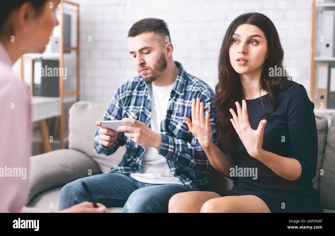 Angry woman talking to psychiatrist at couple counseling session Stock Photo