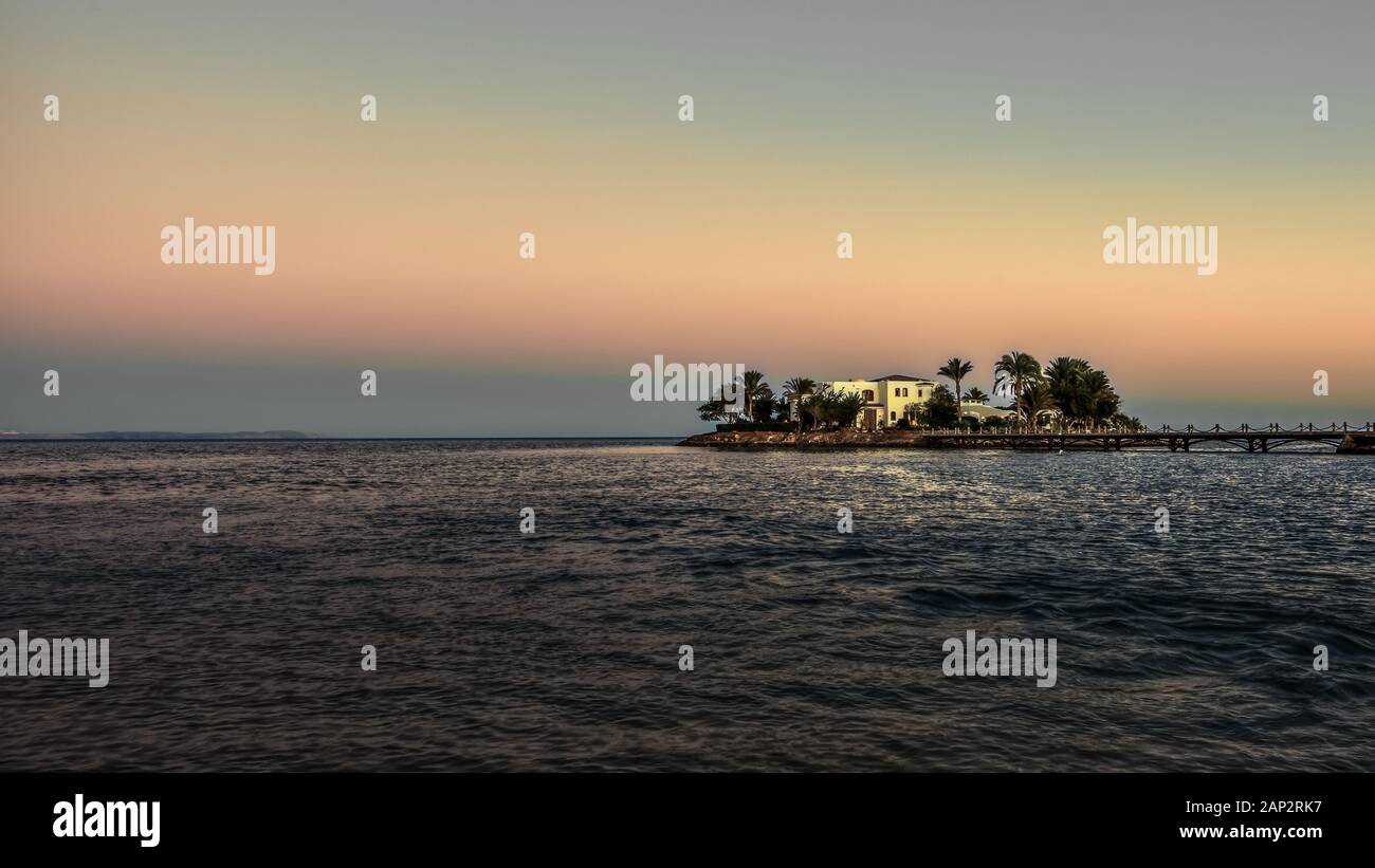 White Villa on a small island with palms and a bridge in the twilight evening light, El Guna, Egypt, January 07, 2020 Stock Photo