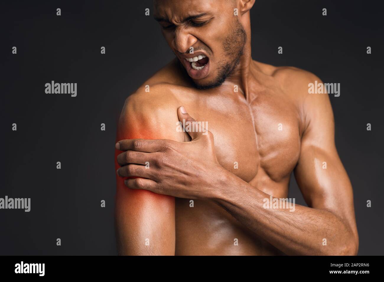 Handsome shirtless black man suffering from pain in arm Stock Photo - Alamy, image size:1300x956