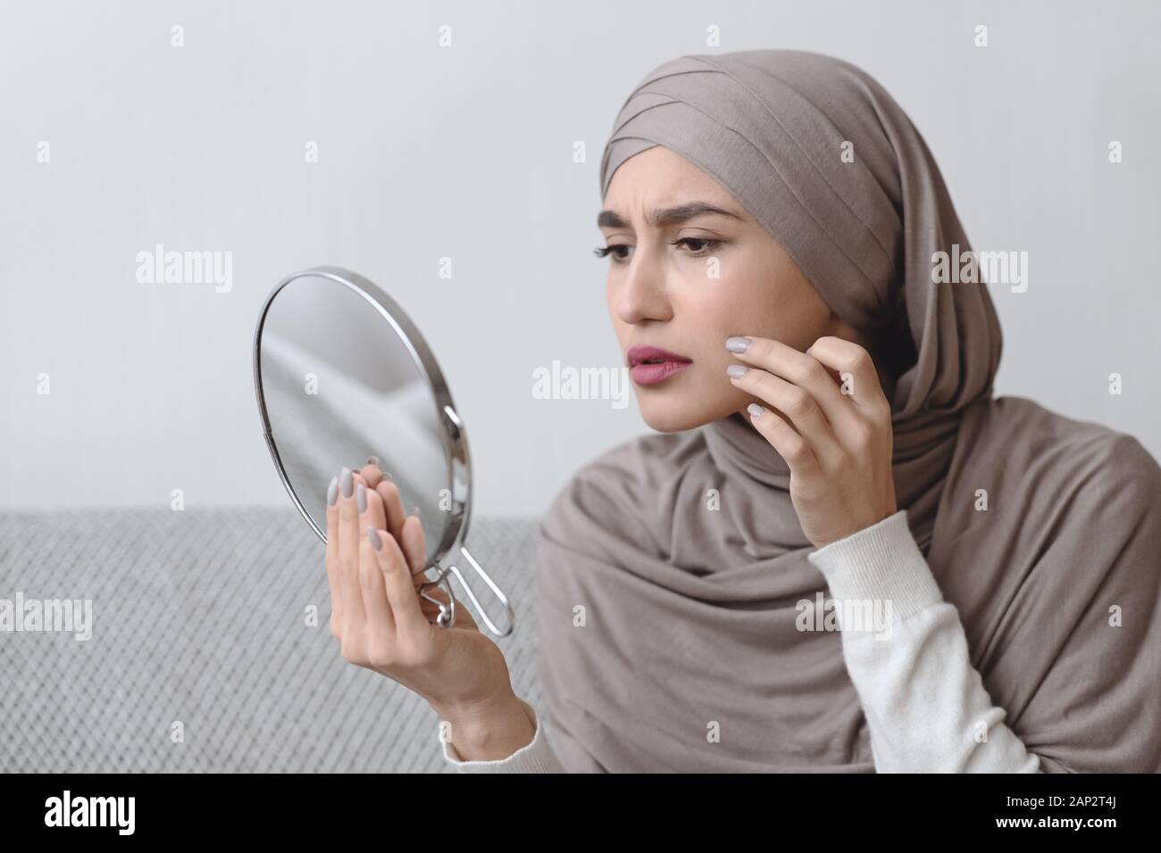 Muslim Girl In Hijab Looking In Round Mirror And Touching Skin Stock ...