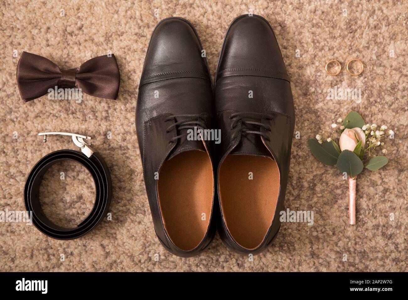 Groom accessories and black shoes on brown floor background Stock Photo