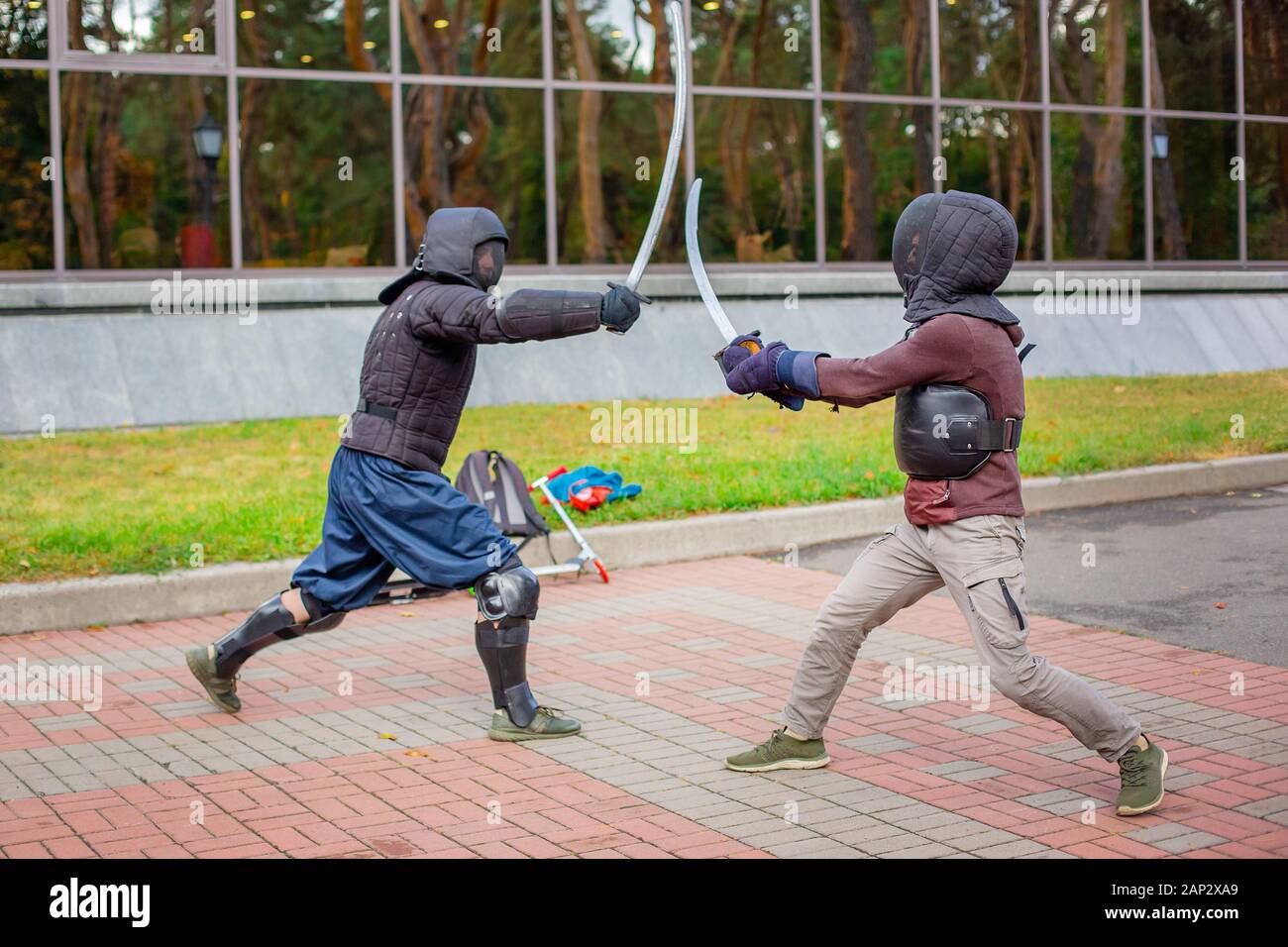 Two armed men lead a sword fight, a medieval fight, at a fun medieval tournament. Sports competitions. Gladiator fights. Stock Photo