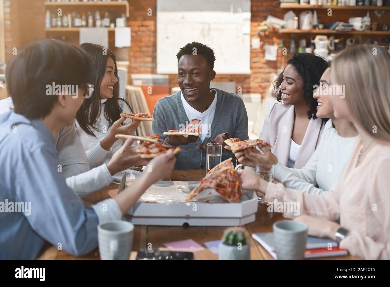 Happy people eating lunch at coworking office during break Stock Photo