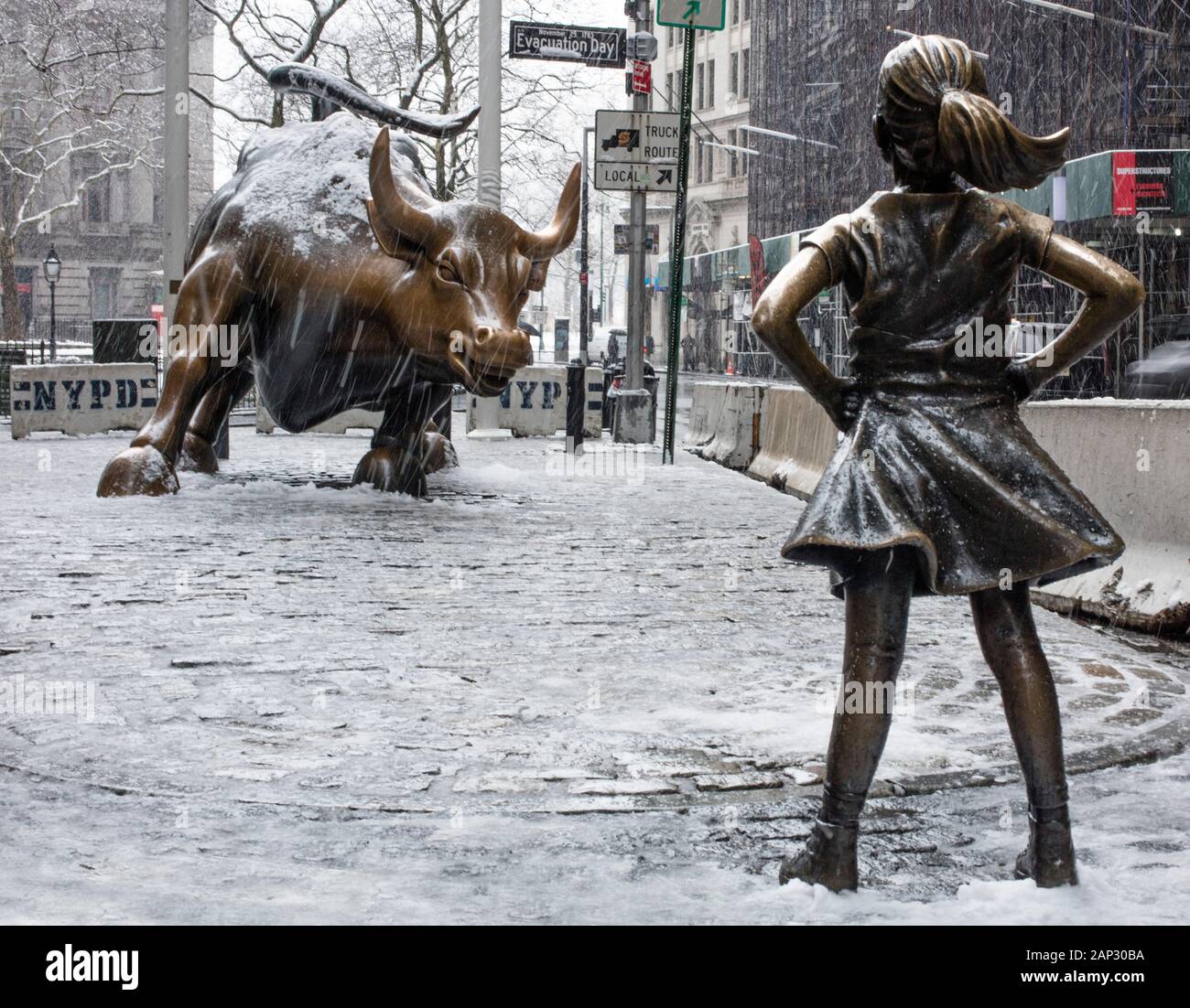 Fearless Girl statue in previous position in front of Wall Street Charging Bull Stock Photo