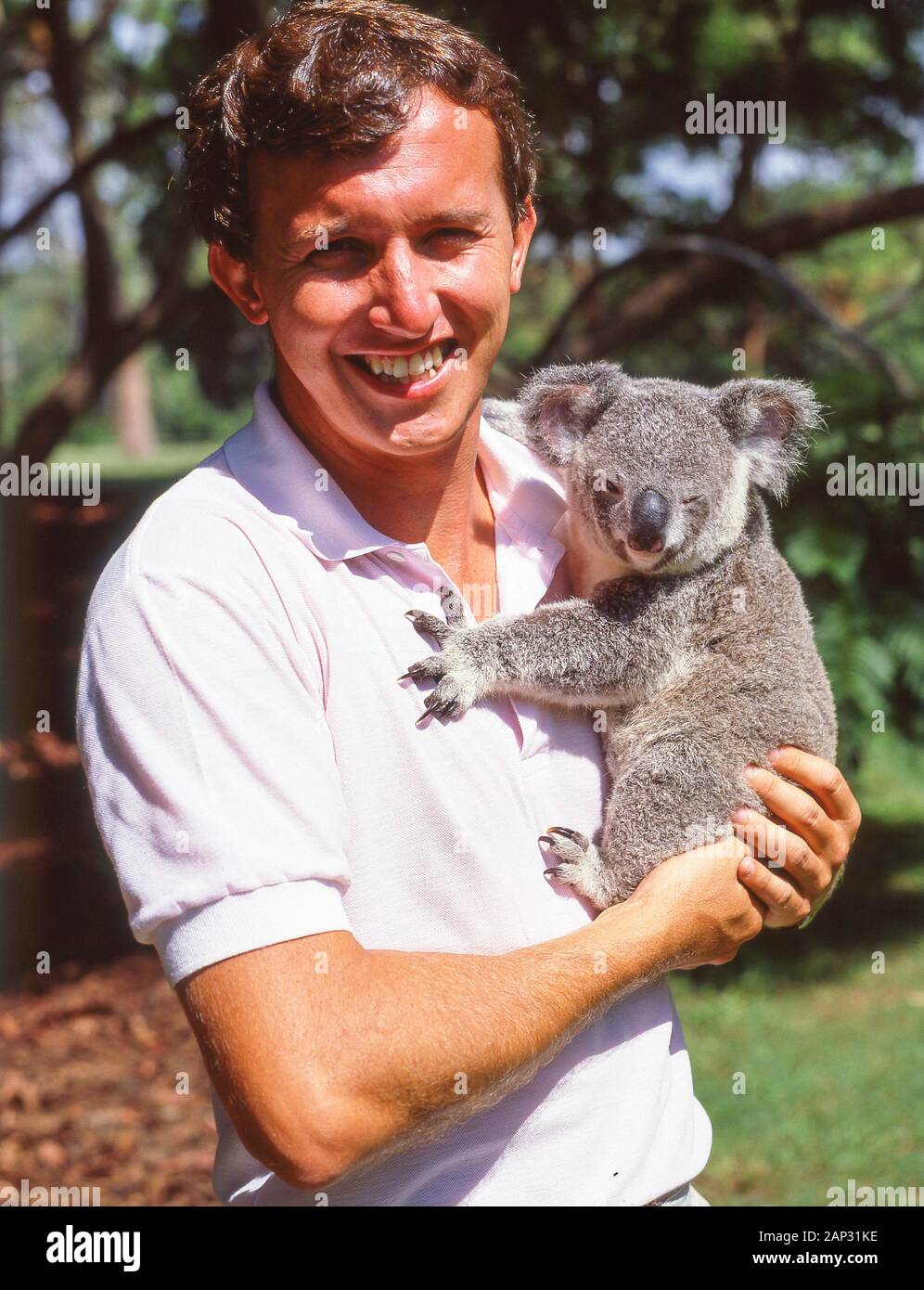 Young man holding Koala at Lone Pine Koala Sanctuary, Fig Tree Pocket, Brisbane, Queensland, Australia Stock Photo