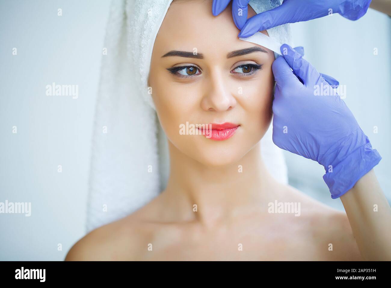 Beautician waxing young woman's eyebrows in spa center Stock Photo Alamy