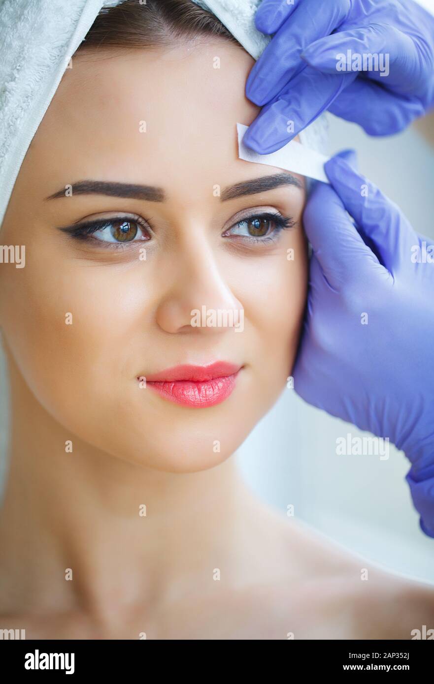 Beautician waxing young woman's eyebrows in spa center Stock Photo Alamy