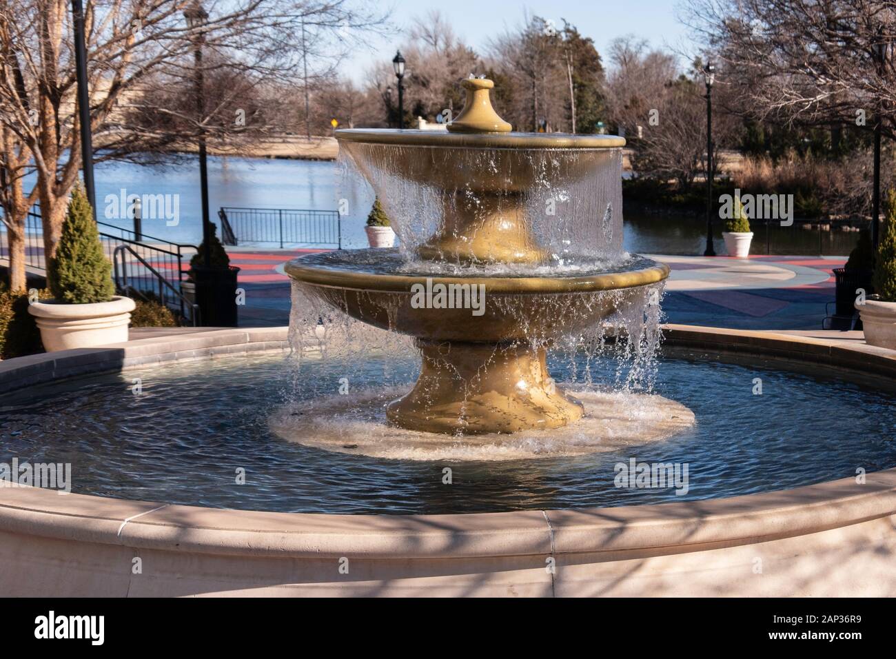 A large two-tiered fountain in a plaza by a lake. Bradley Fair mall plaza, Wichita, Kansas, USA. Stock Photo