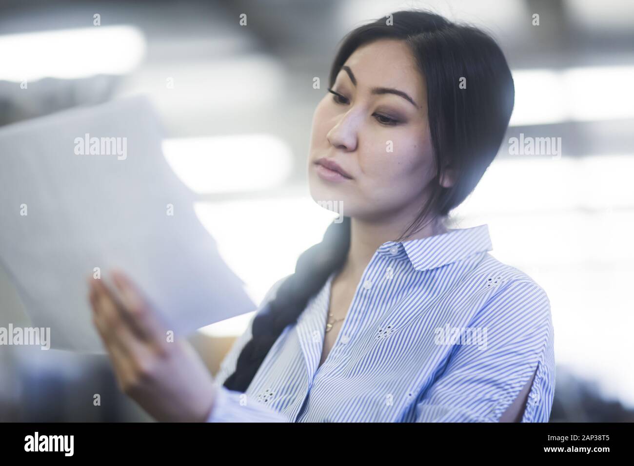 young asia woman with paper in an office concentrate Stock Photo