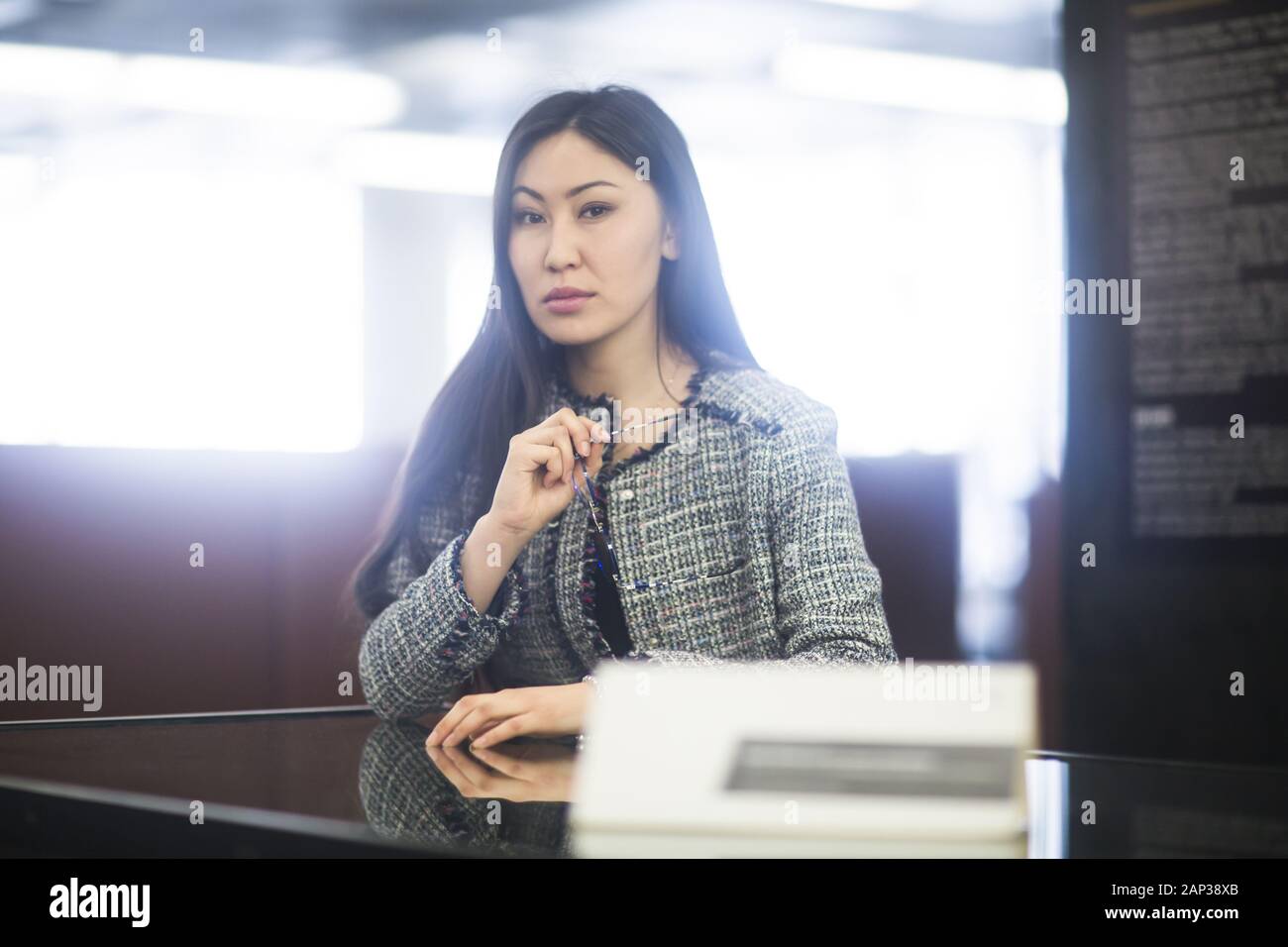 young asia woman with paper in an office sitting Stock Photo