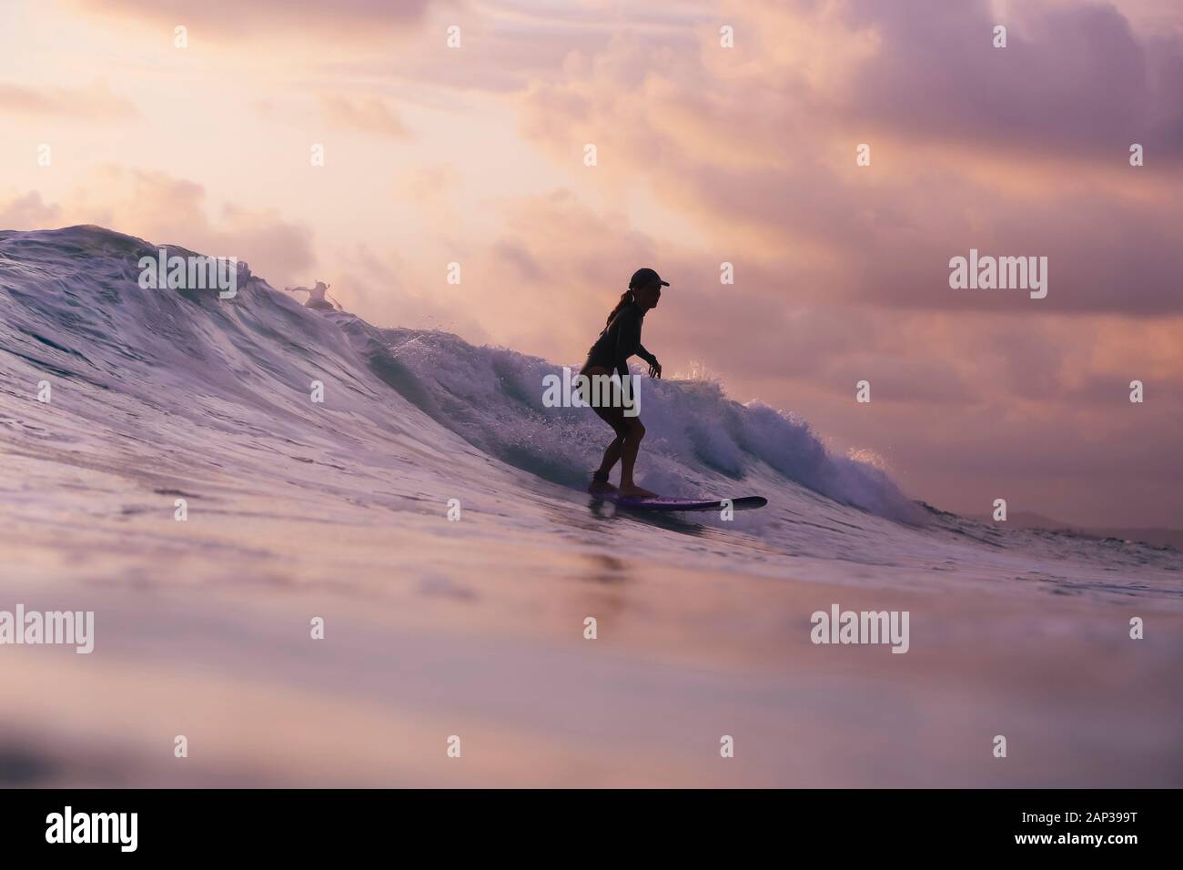Woman surfing at sunset hi-res stock photography and images - Alamy