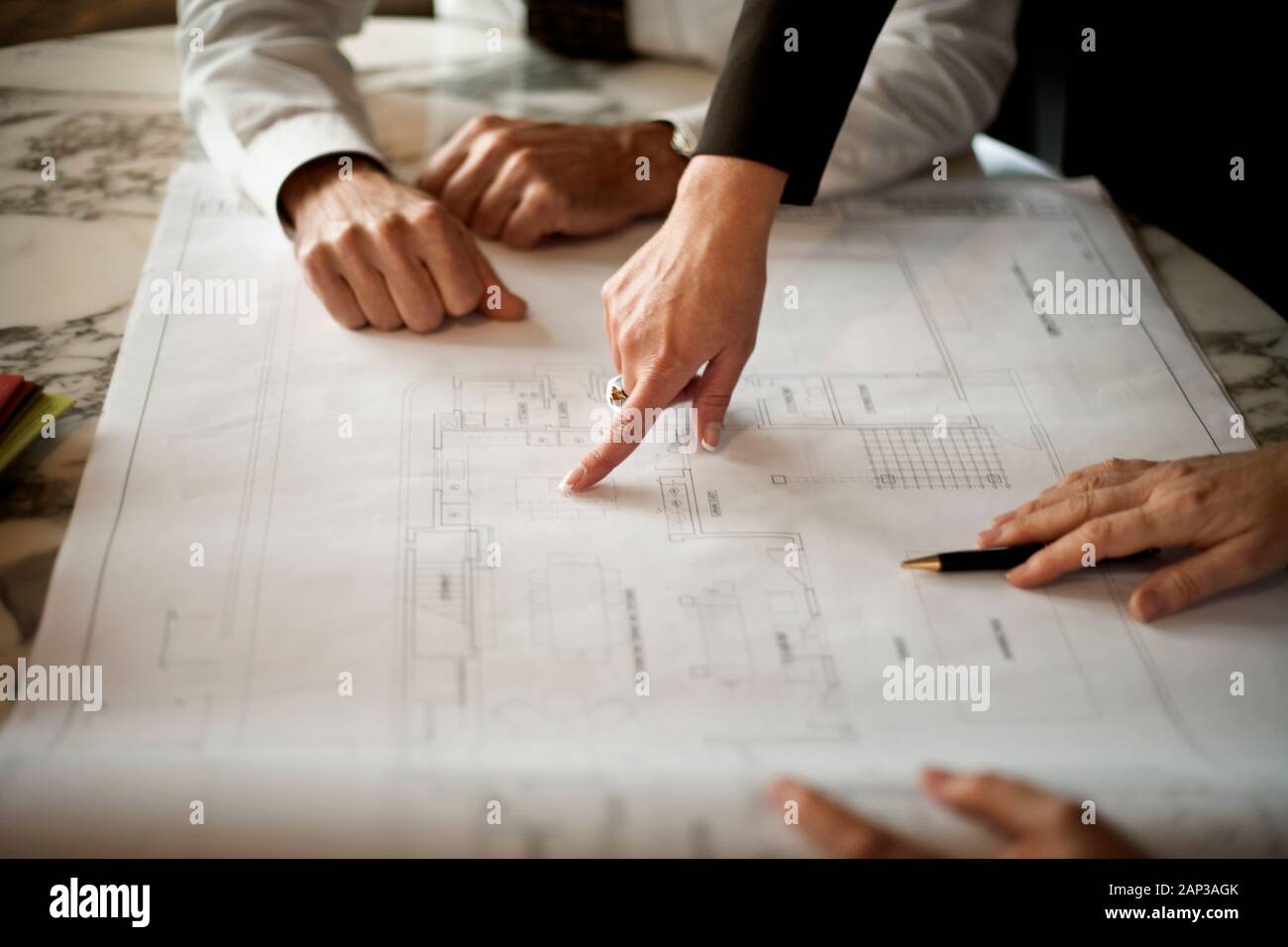People working on architectural blueprint. Stock Photo