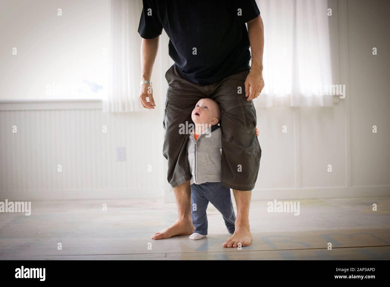 Baby with fathers long legs Stock Photo - Alamy