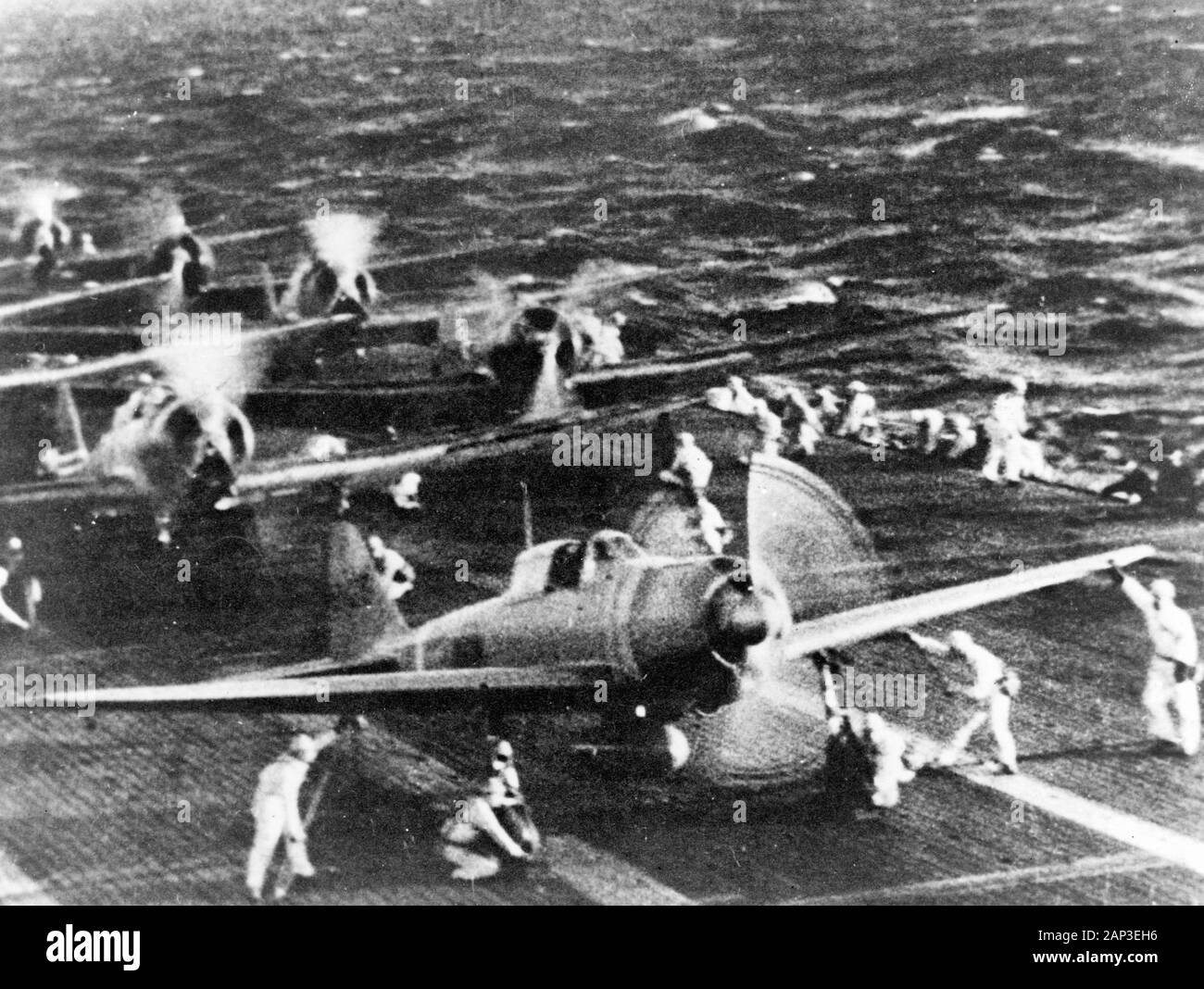 Pearl Harbor Attack, 7 December 1941. Japanese naval aircraft prepare to take off from an aircraft carrier (reportedly Shokaku) to attack Pearl Harbor during the morning of 7 December 1941. Plane in the foreground is a 'Zero' Fighter, in front of 'Val' dive bombers. This is probably the launch of the second attack wave. Stock Photo