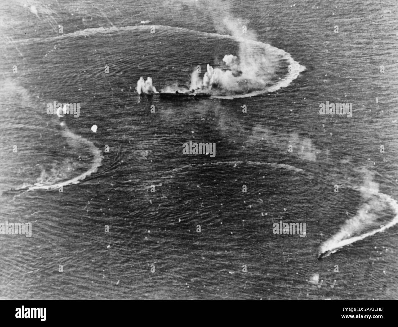 Battle of the Philippine Sea: the Japanese aircraft carrier Zuikaku (center) and the destroyers Akizuki and Wakatsuki maneuvering, while under attack by U.S. Navy carrier aircraft, during the late afternoon of 20 June 1944. Zuikaku was hit by several bombs during these attacks, but survived. Stock Photo