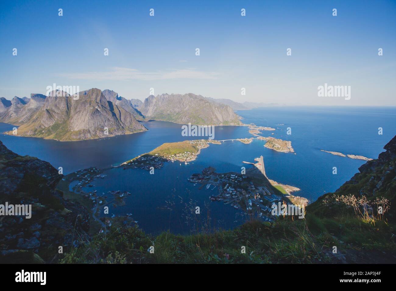 Beautiful norwegian landscape with famous top peak Reinbringen, Lofoten Islands, with a group of hikers tourists, and with a view on famous Reine city Stock Photo