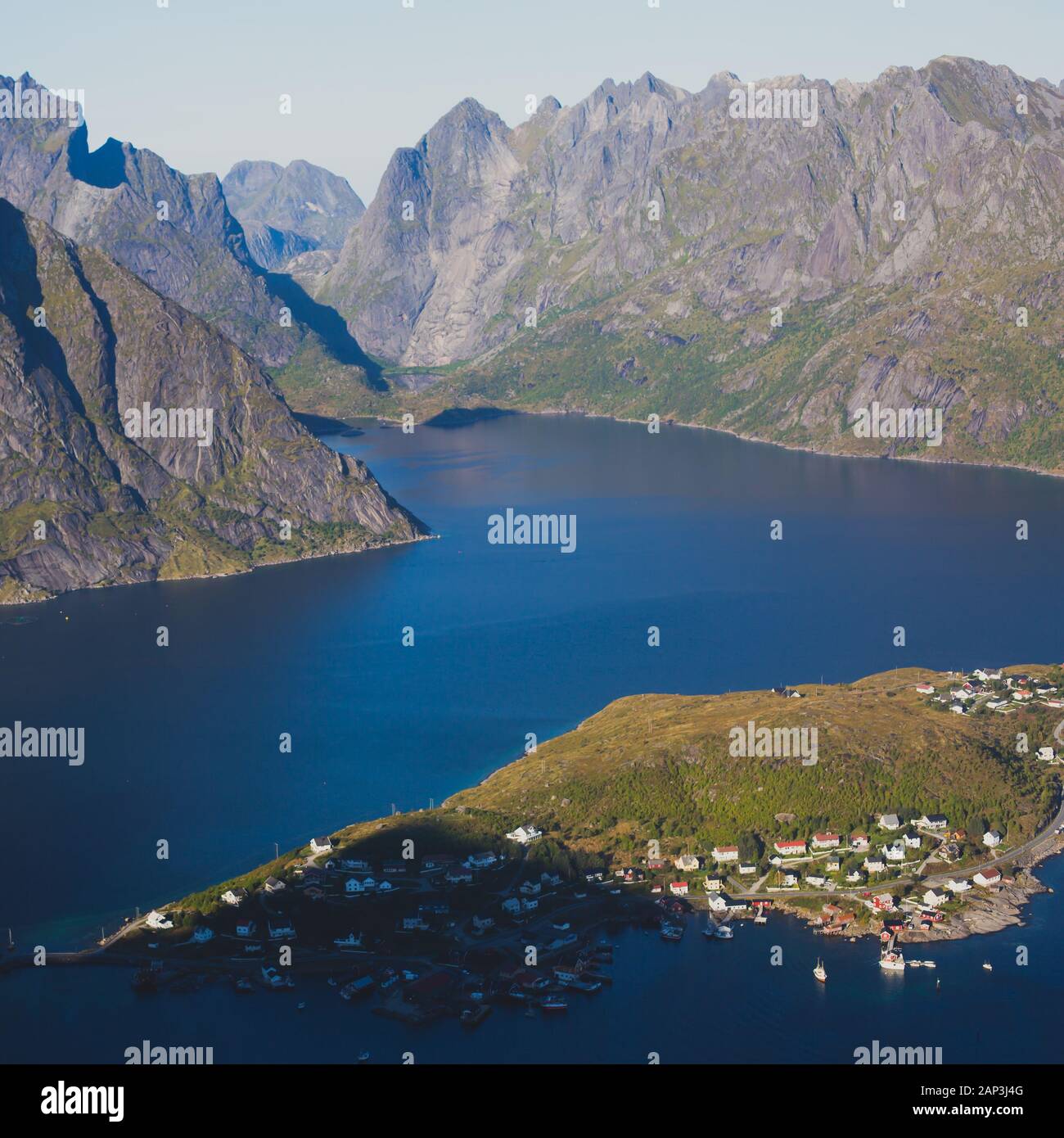 Beautiful norwegian landscape with famous top peak Reinbringen, Lofoten Islands, with a group of hikers tourists, and with a view on famous Reine city Stock Photo