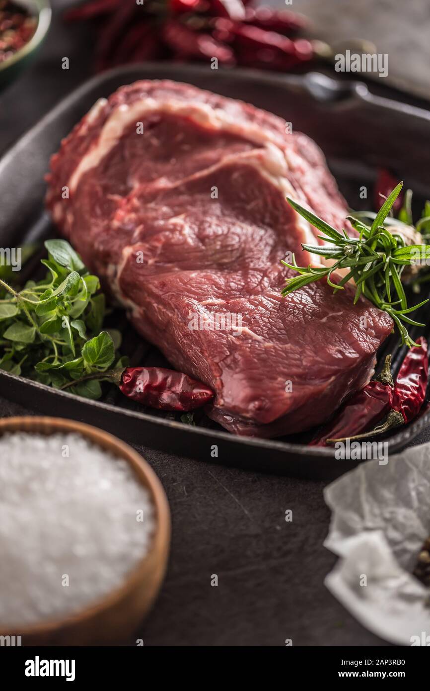 Beef ribe eye in pan with rosemary oregano salt pepper spices garlic and tomatoes Stock Photo Alamy