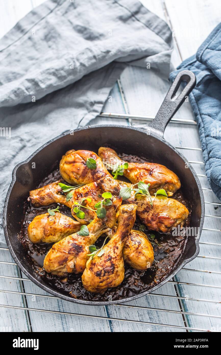Roasted chicken legs in pan with herbs - close up Stock Photo