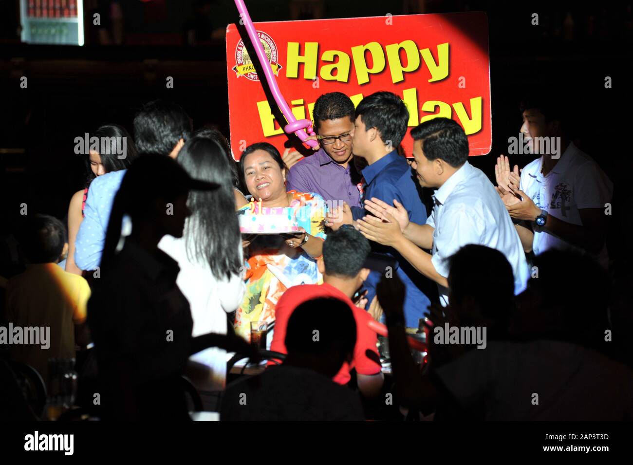 Happiness, Cambodian Birthday Party w/ birthday cake & sign, Spark & Tawandang German Brewery, Phnom Penh, Cambodia, Indochina. © Kraig Lieb Stock Photo