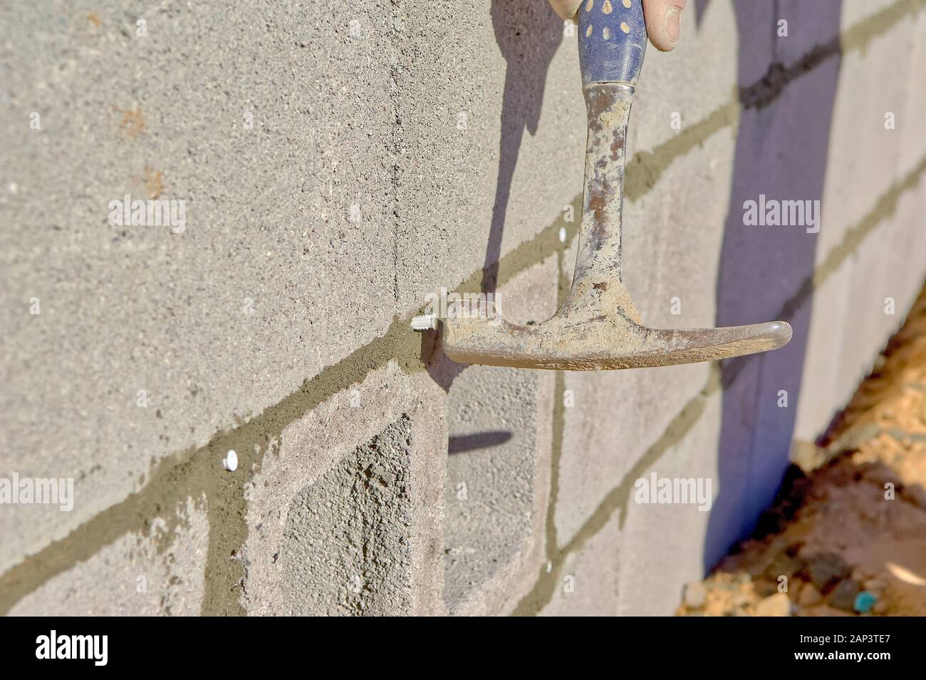 A hammer, captured at the moment of impact, hammering a plastic screw ...