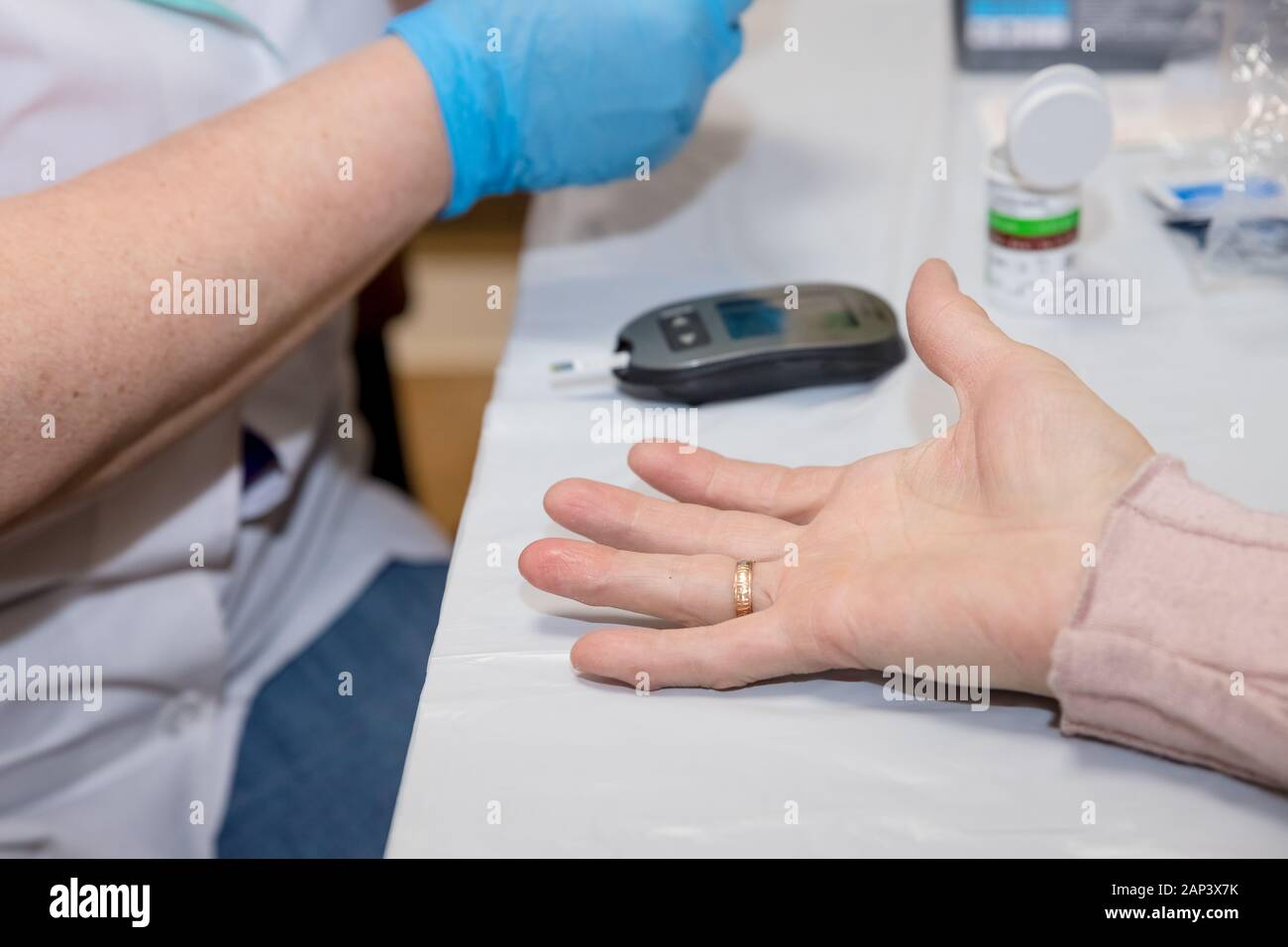 Doctor testing a patients glucose level after pricking his finger to