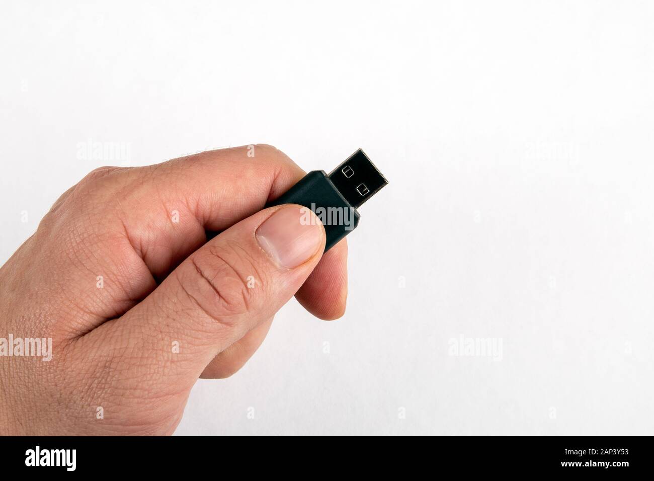 USB memory stick in male hand on white background with copy space. Data, information, security