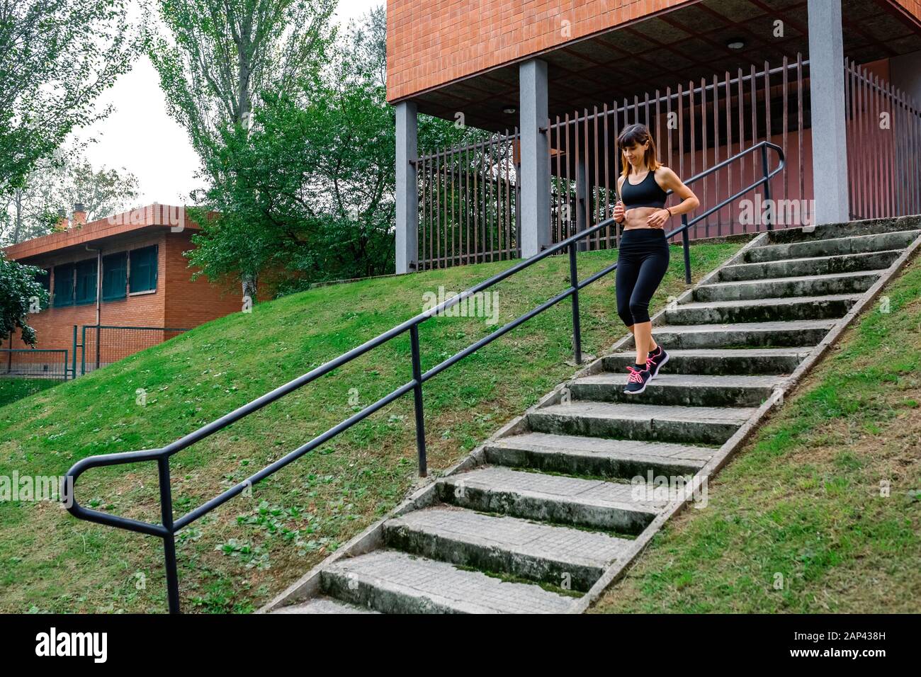 Female athlete going down stairs outdoors Stock Photo