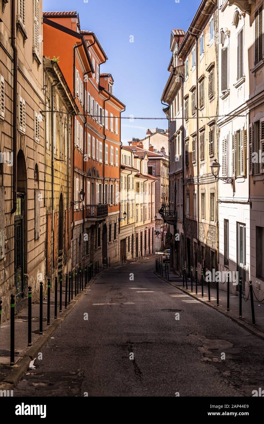 Narrow empty street 'via felice venezian' in old town trieste in Italy. Facades of old and colorful mediterranean houses visible Stock Photo