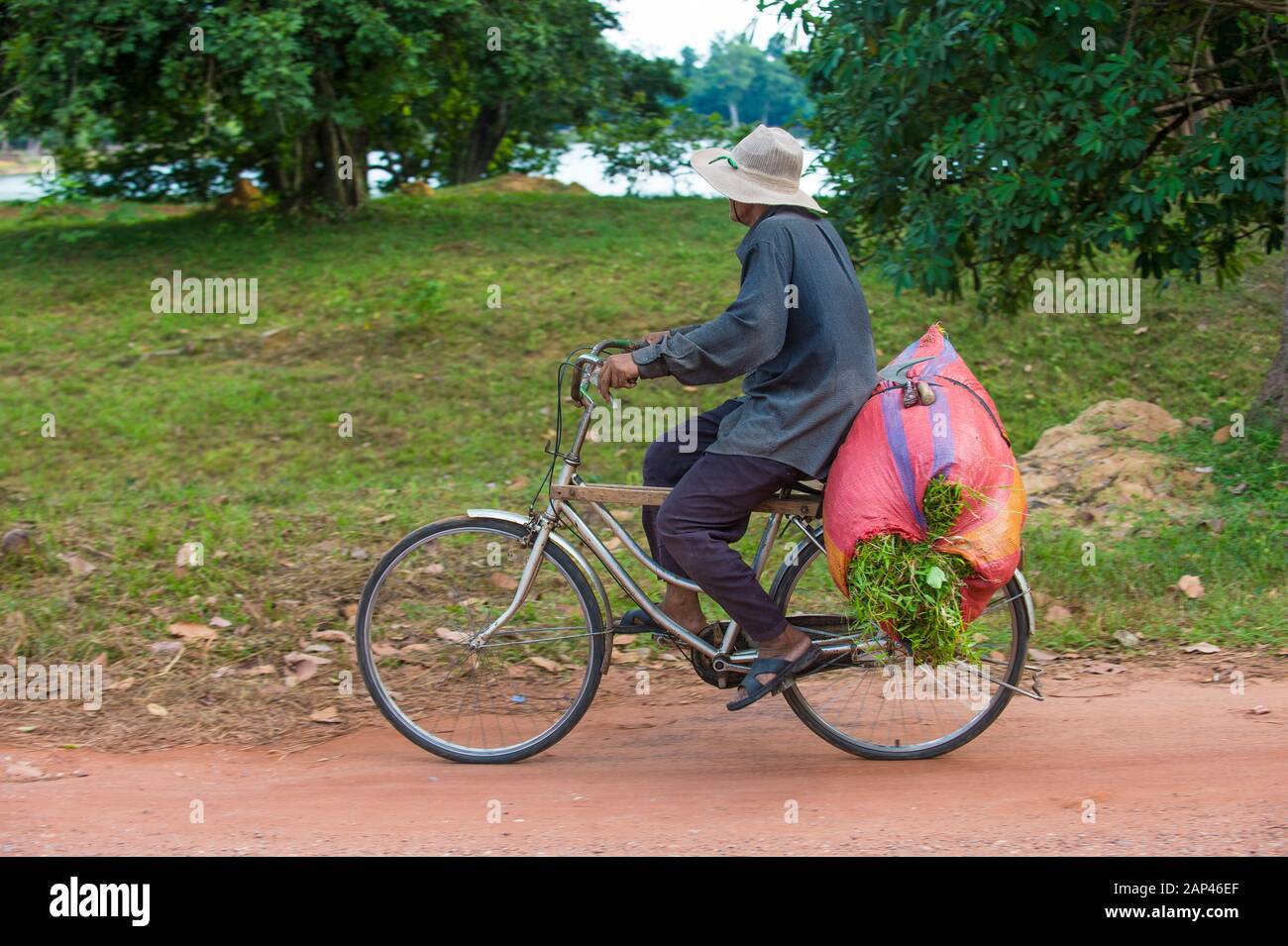 Cambodian farmer travels on his bicycle in a village near Siem Reap Cambodia Stock Photo