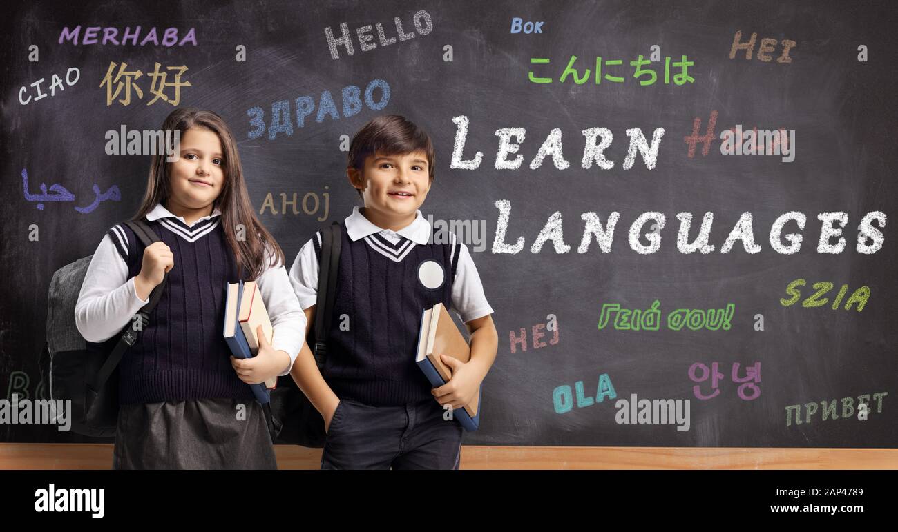 Children in school uniforms in front of a blackboard with text