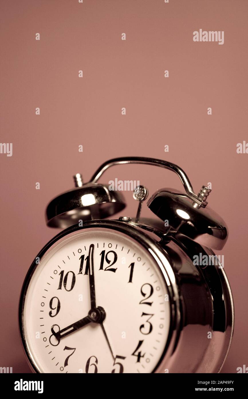 Vintage alarm clock on a solid color background Stock Photo - Alamy