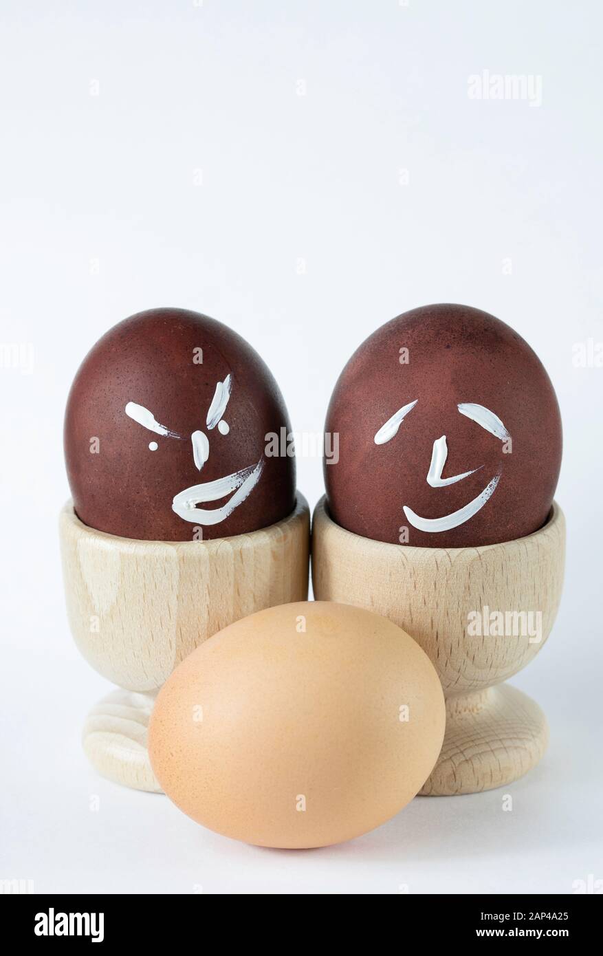 Painted and raw eggs. Funny drawings on eggshells. Easter artistic decoration. Stock Photo