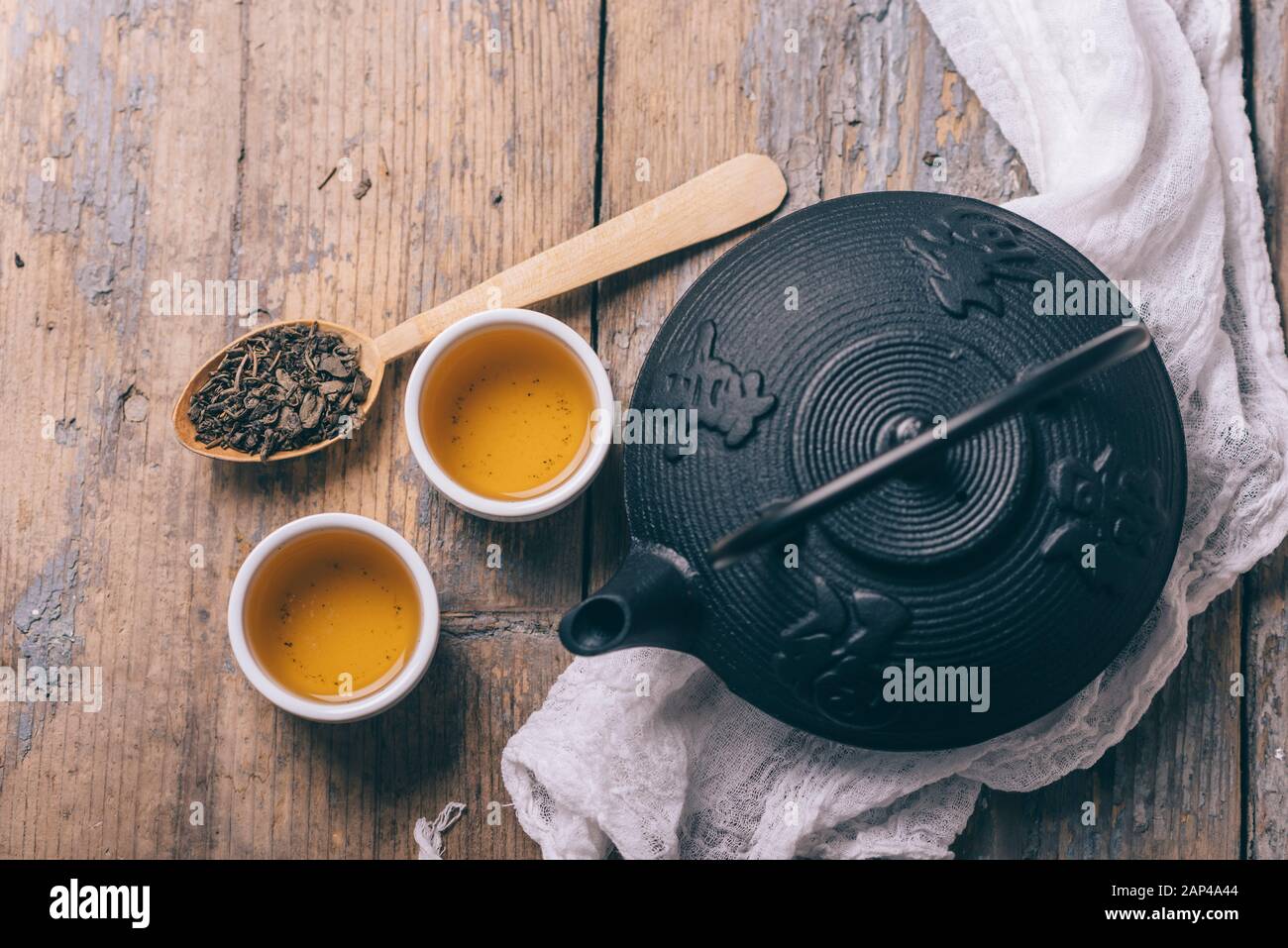 Traditional japanese herbal tea recipe prepared in cast iron teapot with organic dry herbs from