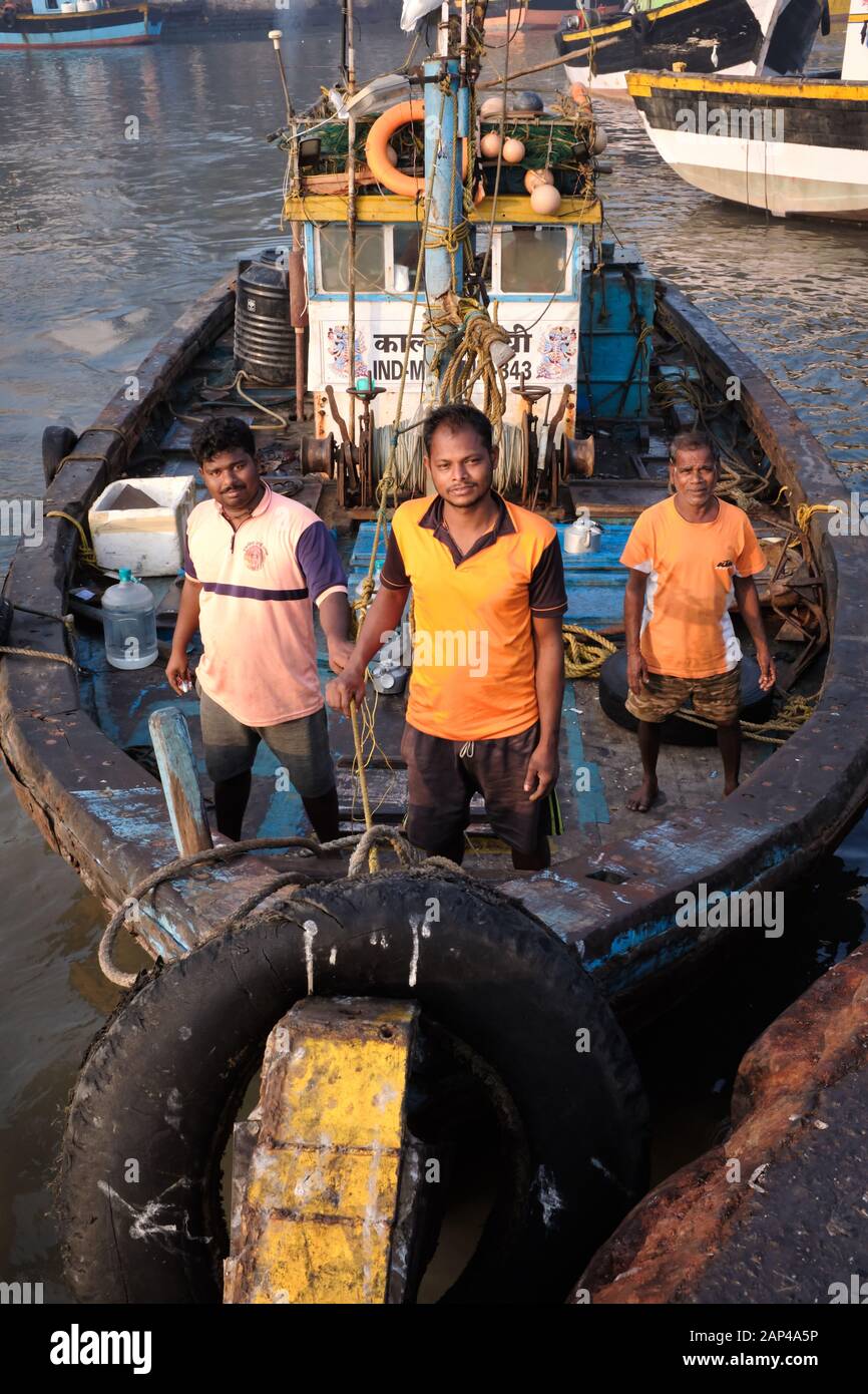 Three fishermen on their fishing boat anchored at at Sassoon Docks, a ...