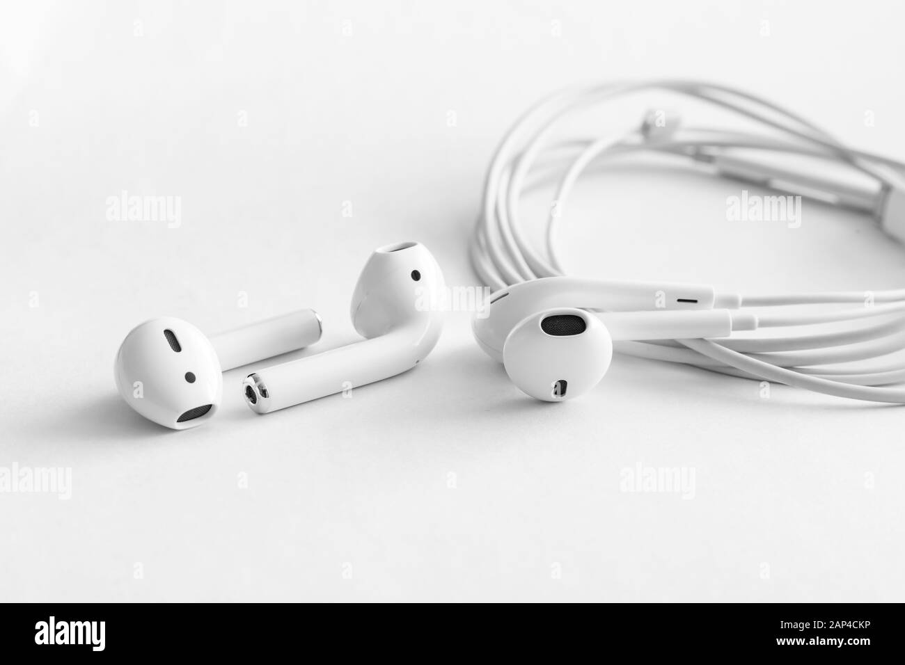 White headphones wireless comparison with wired earphones, copy space