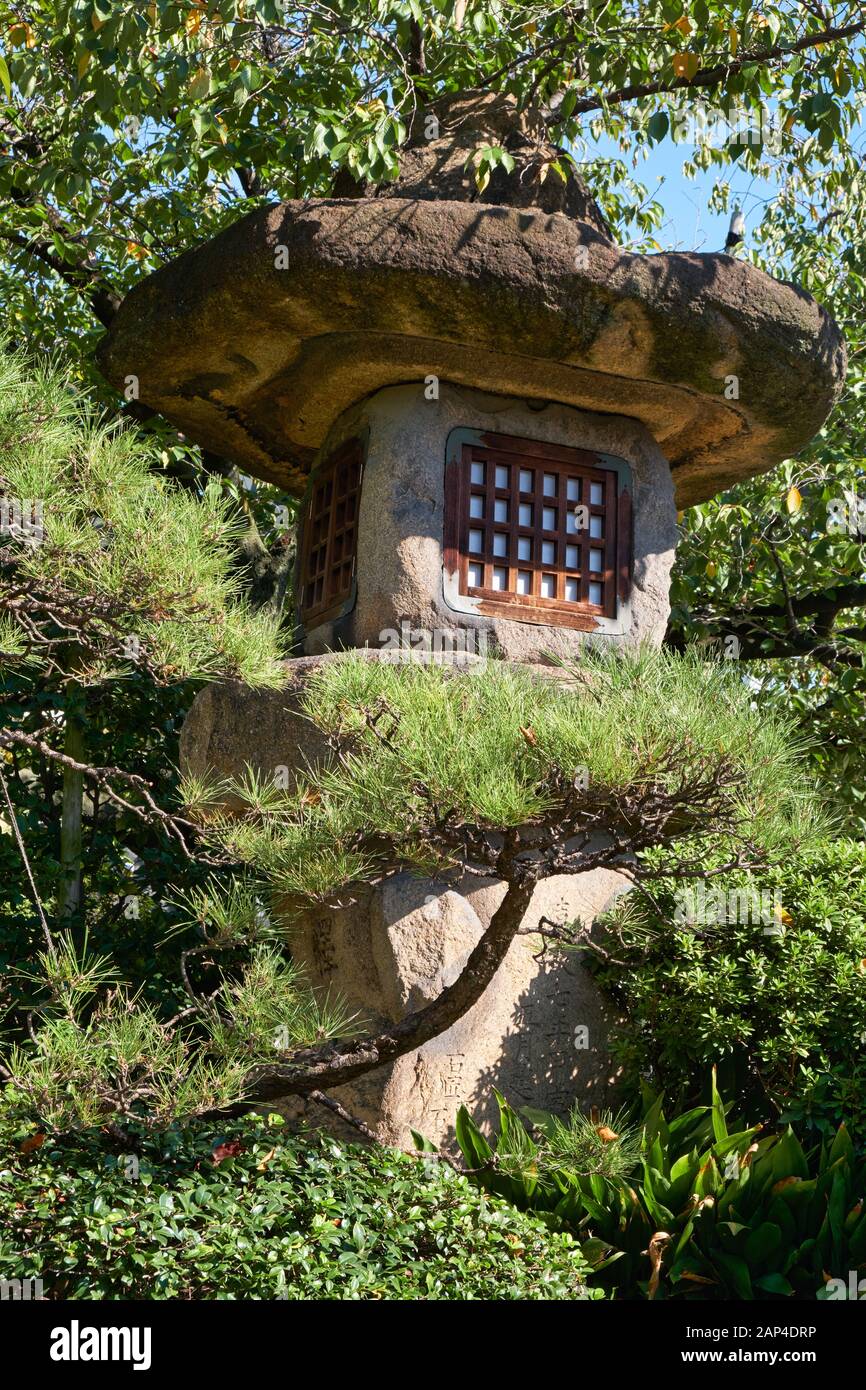 The view of Nazura-doro japanese stone lantern made with rough, unpolished stones in the Isshin-ji Temple of Osaka. Japan Stock Photo