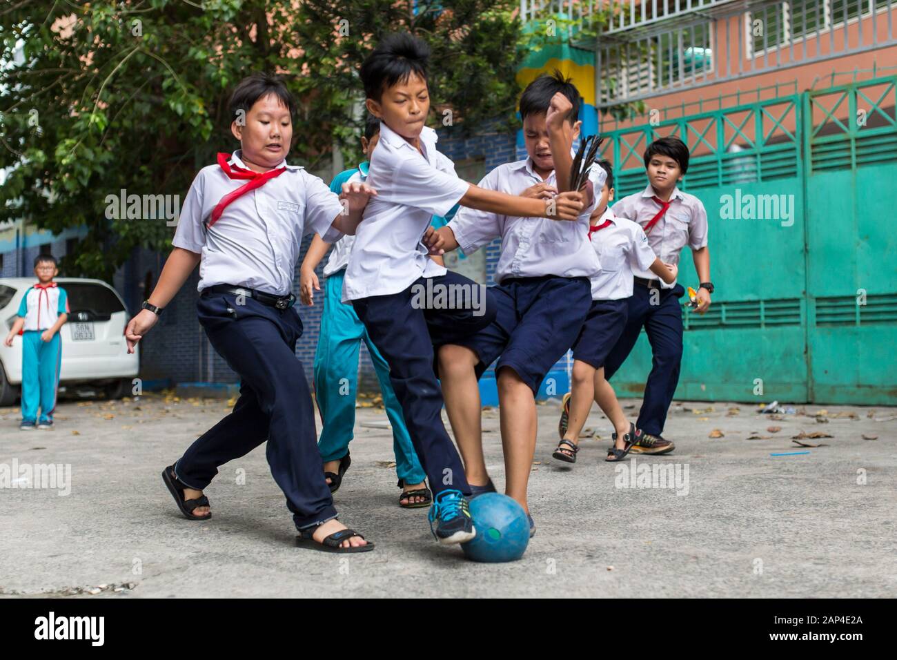 HO CHI MINH CITY, VIETNAM - October 31, 2016: Vietnamese boys playing football in front of school building in Ho Chi Minh City, Vietnam. Stock Photo